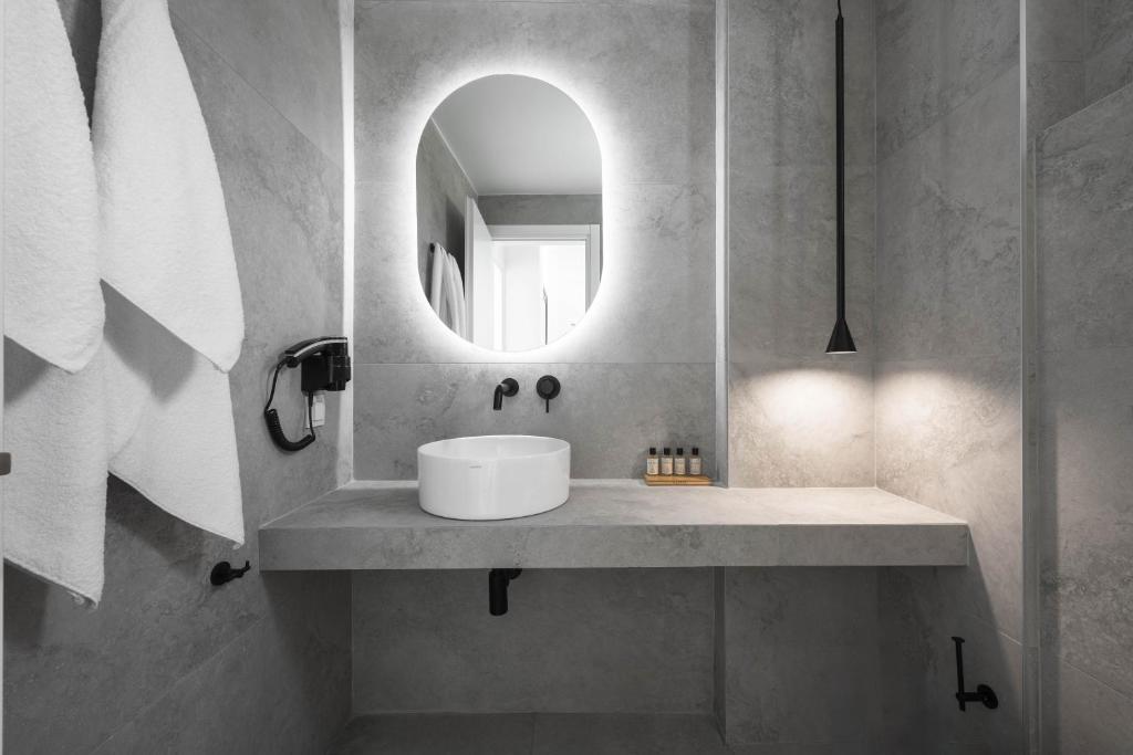 a bathroom with a sink and a mirror at Astrum Luxury Suites in Vourvourou