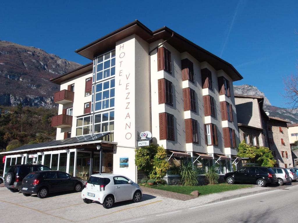 une voiture blanche garée devant un bâtiment dans l'établissement Hotel Vezzano, à Vezzano