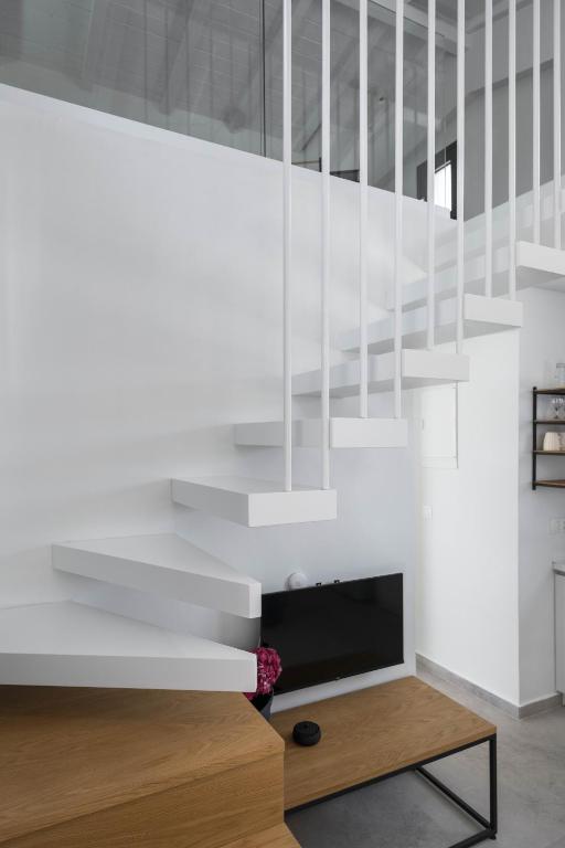 a living room with white walls and a staircase at Astrum Luxury Suites in Vourvourou