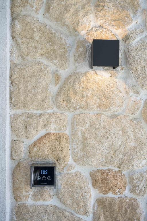 a stone wall with a clock on it at Astrum Luxury Suites in Vourvourou
