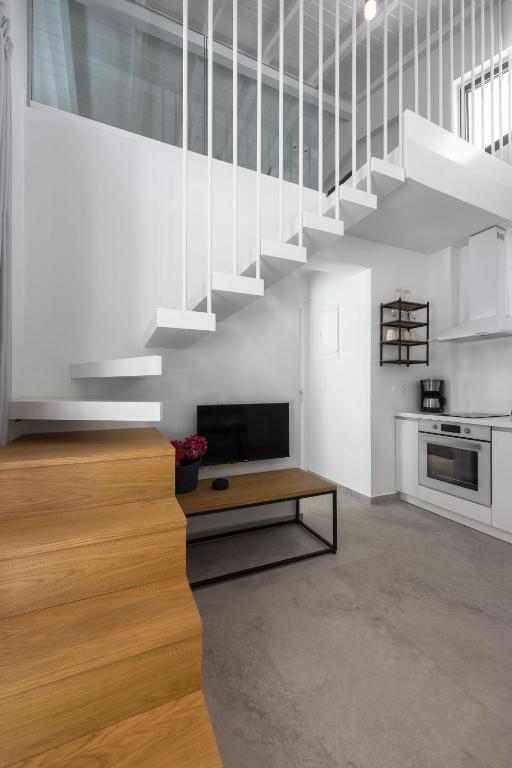 a living room with a staircase and a television at Astrum Luxury Suites in Vourvourou