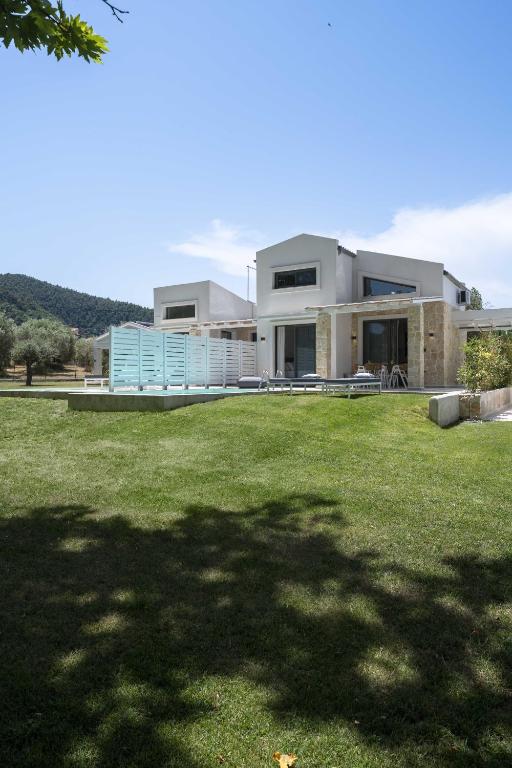 a large house with a lawn in front of it at Astrum Luxury Suites in Vourvourou