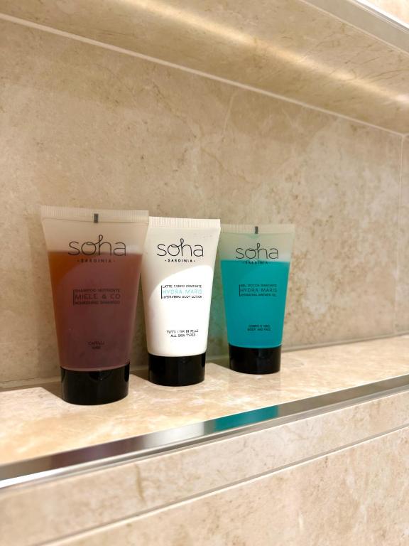 three bottles of sunscreen on a shelf in a store at Feel Boutique Rooms in Oristano