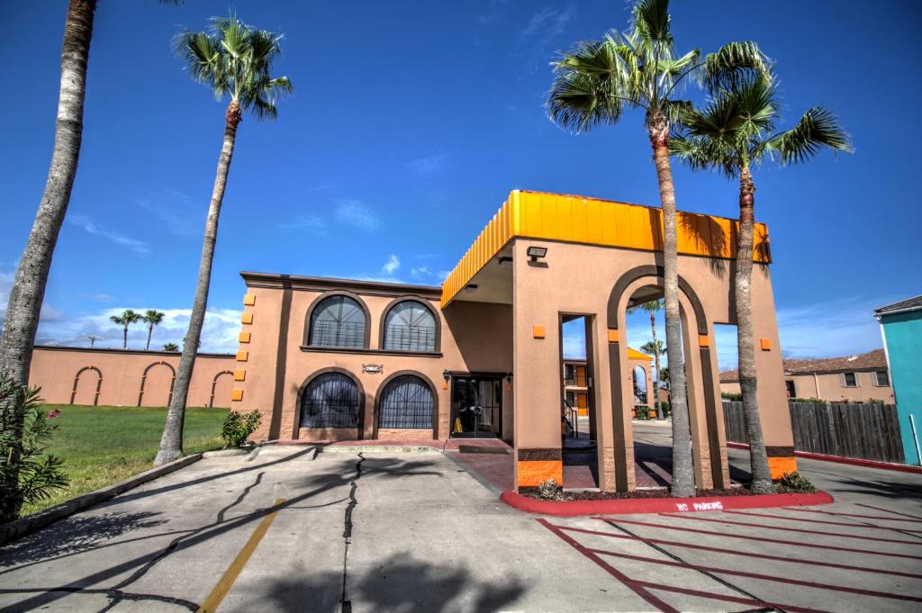 ein Gebäude mit Palmen davor in der Unterkunft South Padre Island Inn in South Padre Island