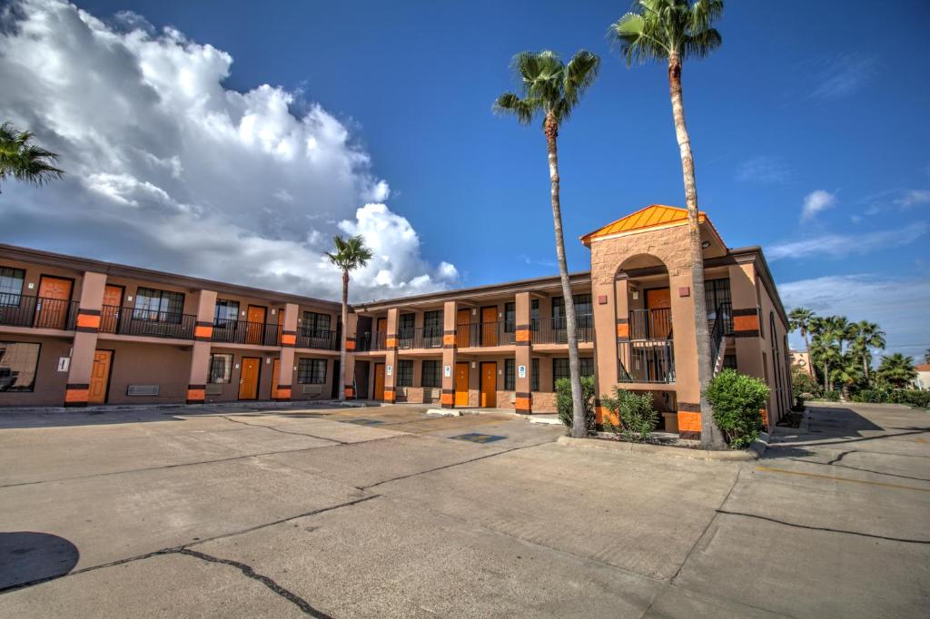 ein leerer Parkplatz vor einem Gebäude mit Palmen in der Unterkunft South Padre Island Inn in South Padre Island