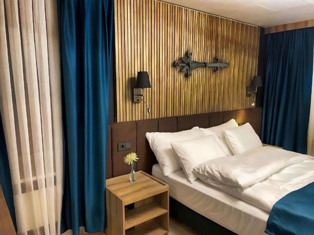 a bedroom with a bed with a cross on the wall at Nani City Hotel in Zürich