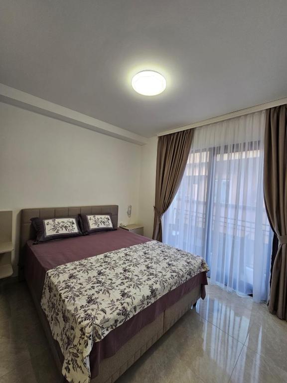a bedroom with a bed and a large window at Apartments Radosavovic in Bar
