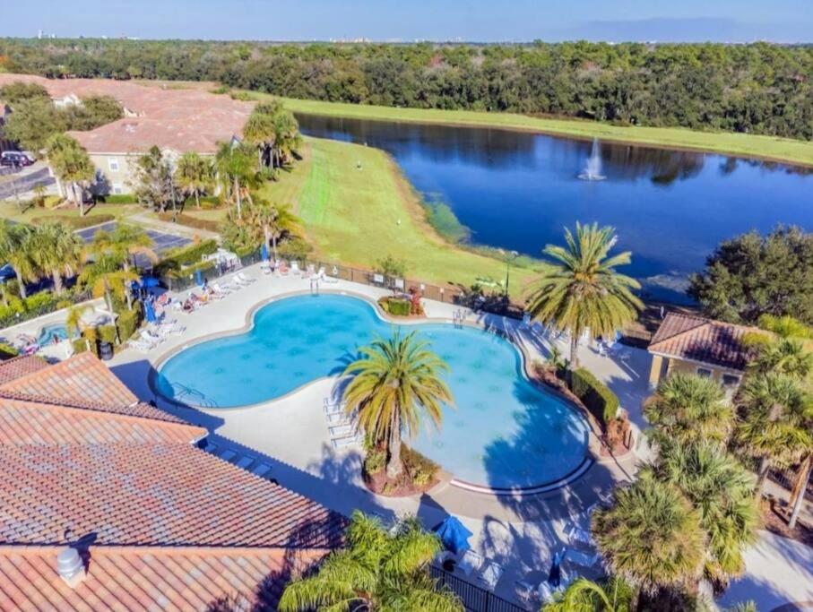 an aerial view of a resort pool with palm trees and a lake at Disney Paradise-Family Friendly- Near to Disney in Orlando