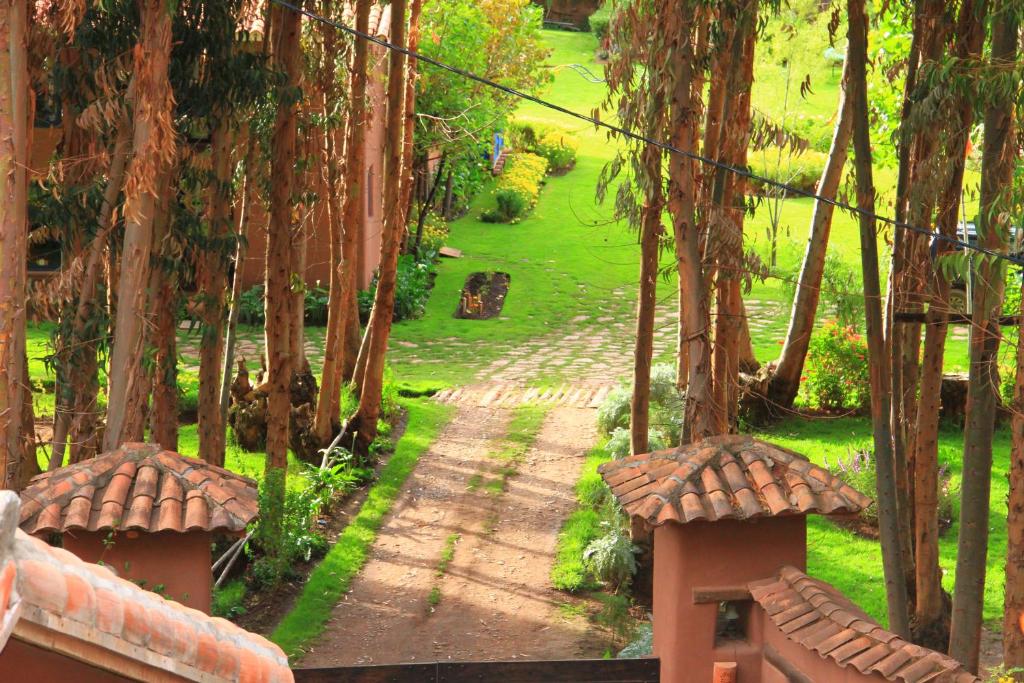 uitzicht op een tuin met bomen en een pad bij Melissa Wasi in Pisac