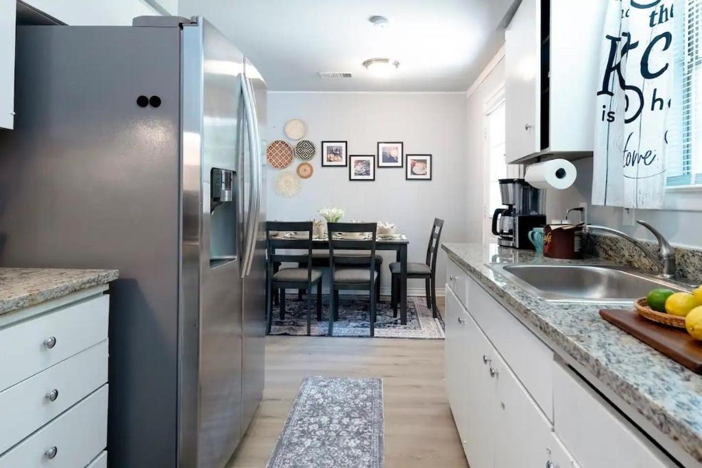 une cuisine avec un réfrigérateur en acier inoxydable et une table dans l'établissement Spacious 3BR Home for 10 Guests Near Downtown Theme Parks & AT&T Stadium 510, à Grand Prairie