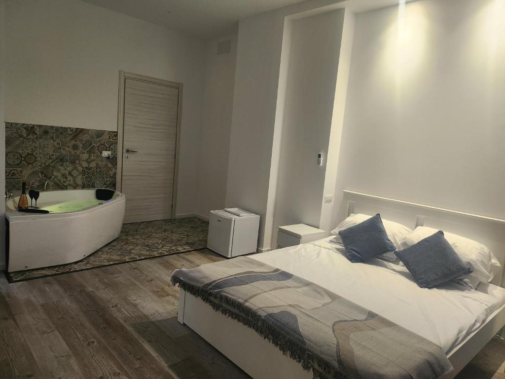 een slaapkamer met een bed en een bad bij Orange boutique rooms in Alghero