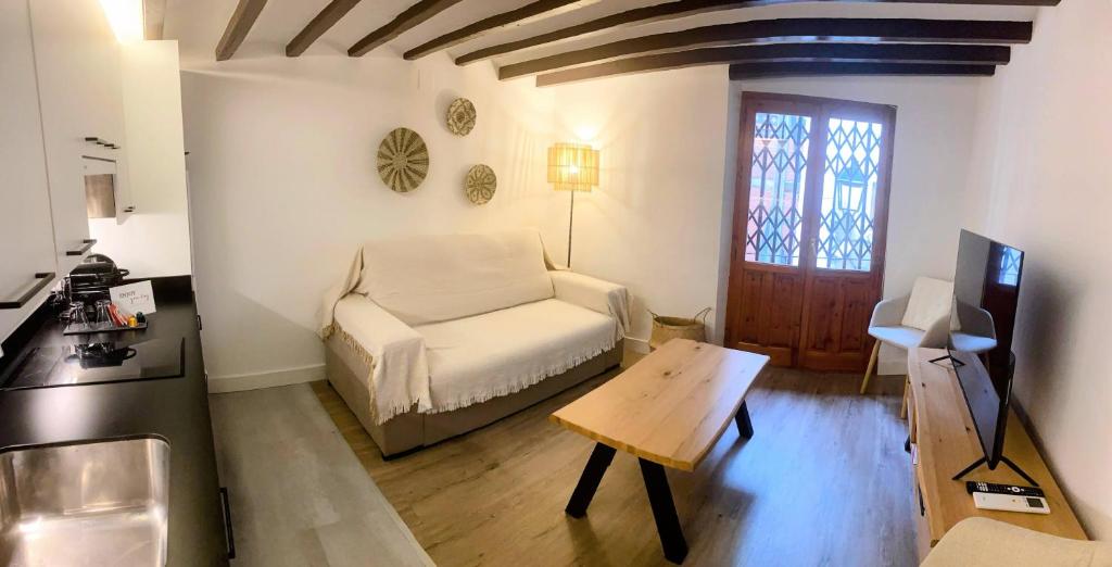a living room with a white couch and a table at Sol y Mar Villajoyosa in Villajoyosa