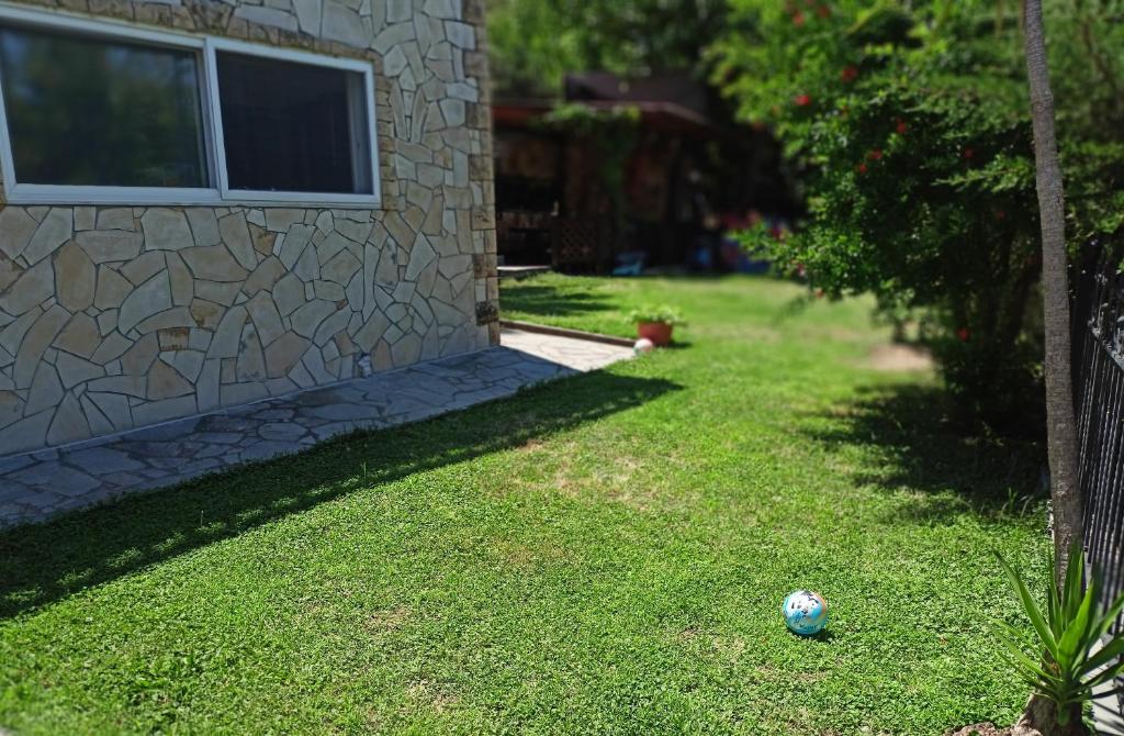 a soccer ball sitting in the grass next to a house at Seaside paradise in Iraklitsa