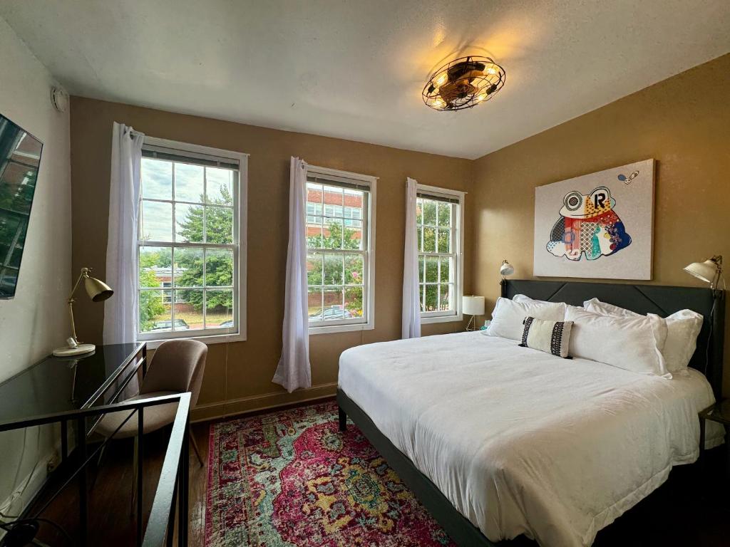 une chambre avec un grand lit et deux fenêtres dans l'établissement Capitol Hill Carriage House, à Washington
