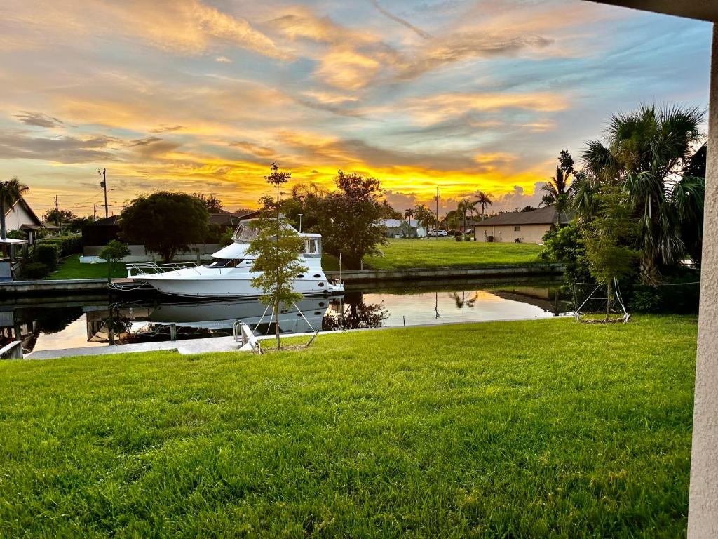 a boat is docked in a river with a sunset at Cape Coral-Ft Myers Waterfront Four Bedroom Home in Cape Coral