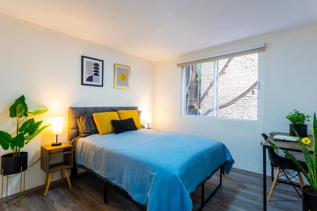a bedroom with a blue bed and a window at Private Room #2 in a 4 bedroom Guest House in Roma Norte, Mexico City in Mexico City
