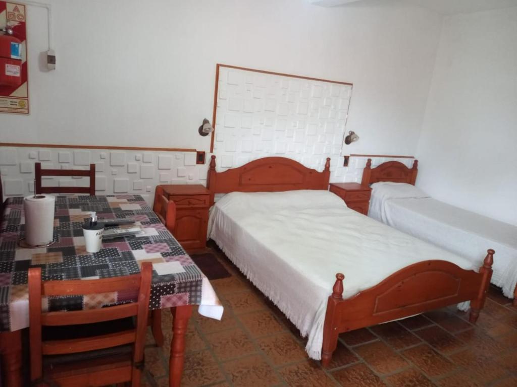 a bedroom with two beds and a desk and a table at Géminis ll in Colón