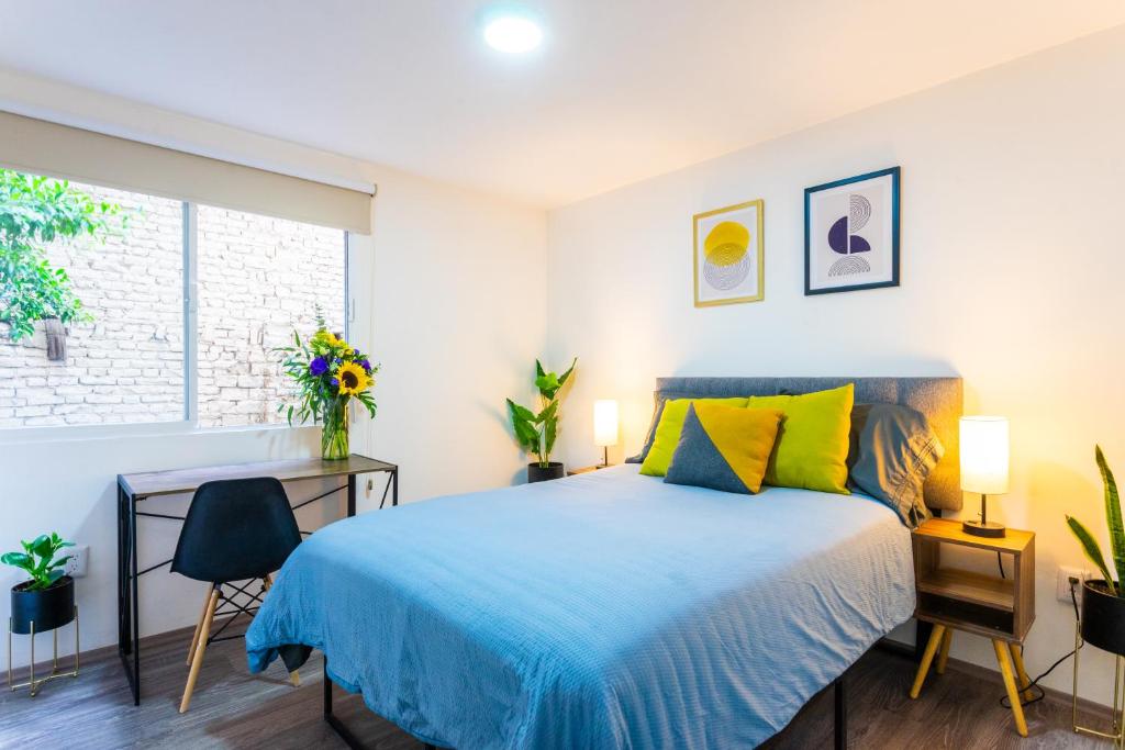 a bedroom with a blue bed and a window at Private Room #3 in a 4 bedroom Guest House in Roma Norte, Mexico City in Mexico City