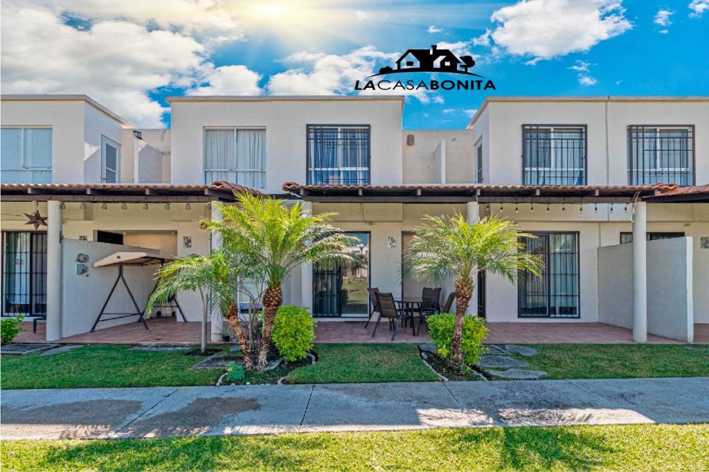 a large white building with palm trees in front of it at LA CASABONITA vistalberca AirA in Alpuyeca