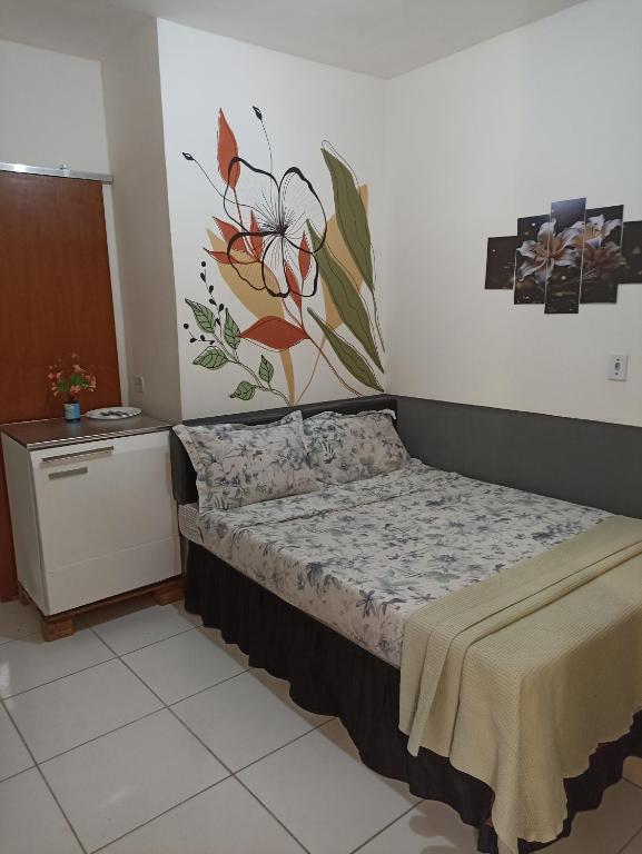 a bedroom with a bed with a flower mural on the wall at Refugio Piratininga térreo 103 in Niterói
