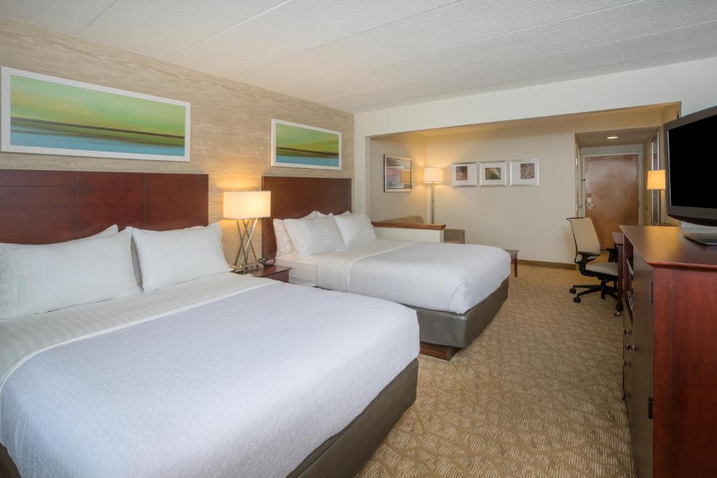a hotel room with two beds and a flat screen tv at Holiday Inn Baltimore BWI Airport by IHG in Linthicum Heights