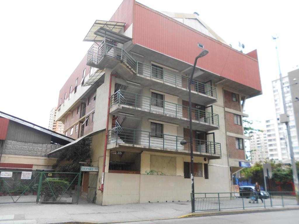 un edificio alto con balcones a un lado. en Aparthotel San Francisco, en Santiago
