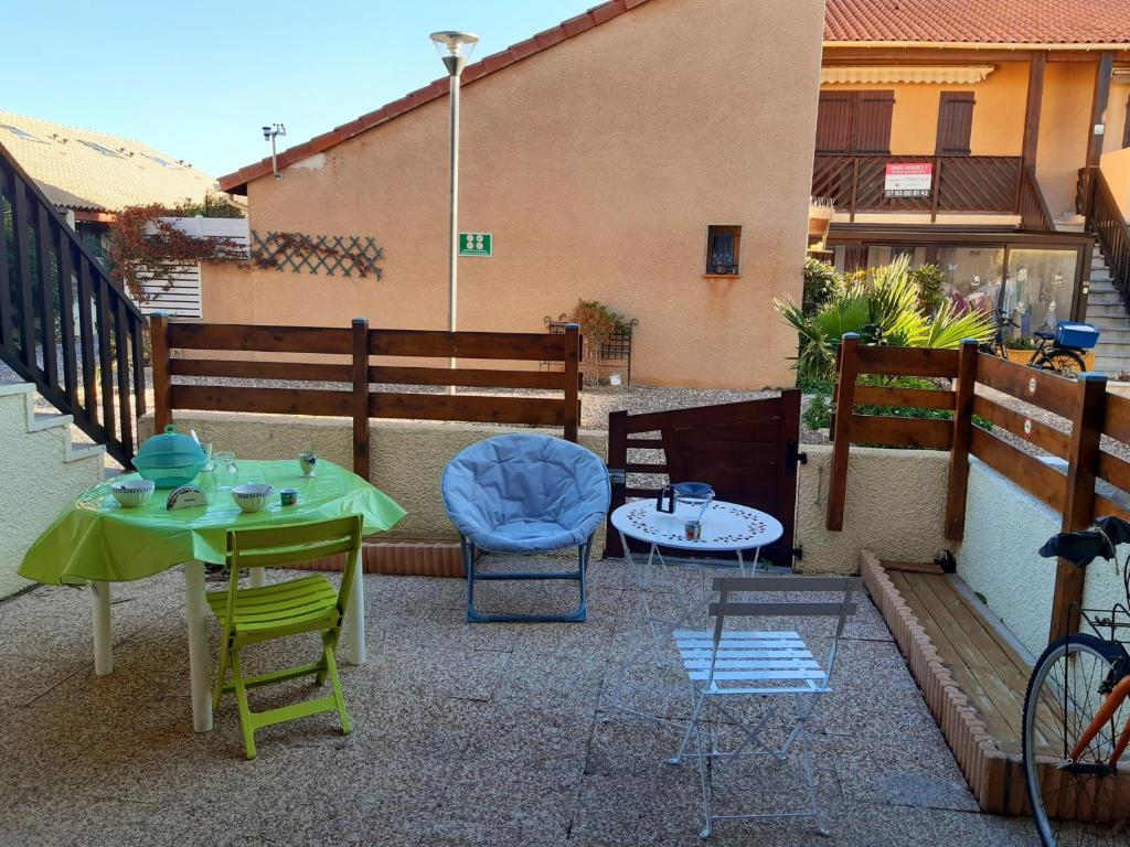un patio avec une table et des chaises sur un balcon dans l'établissement Port Leucate: T2 RDC 4 Pers proche port avec terrasse, parking sécurisé, TV, lave-linge, plancha - FR-1-798-3, à Leucate