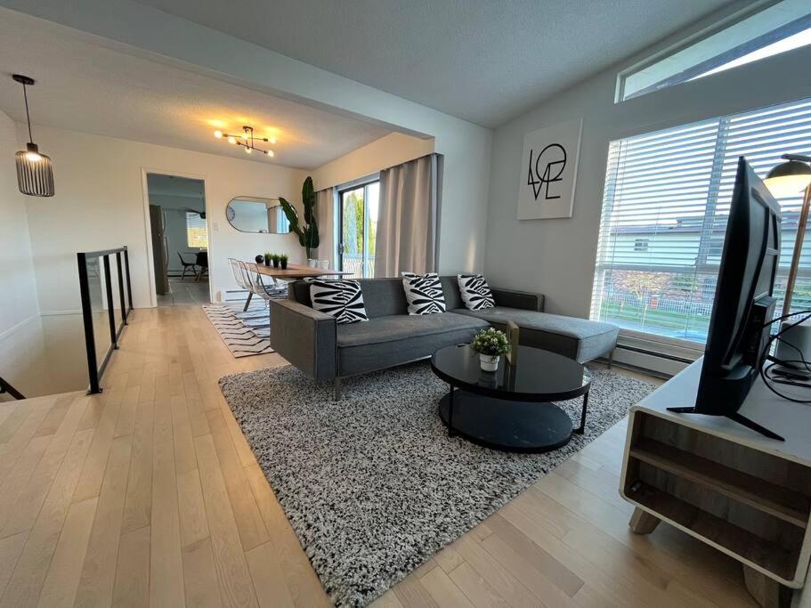 a living room with a couch and a tv at Beautiful Vancouver Special Home in Vancouver