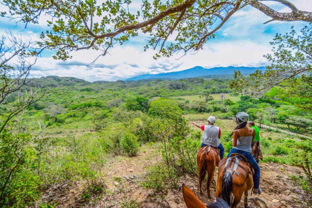 two people riding horses on a trail in the mountains at Vida Aventura Ranch in Tanques