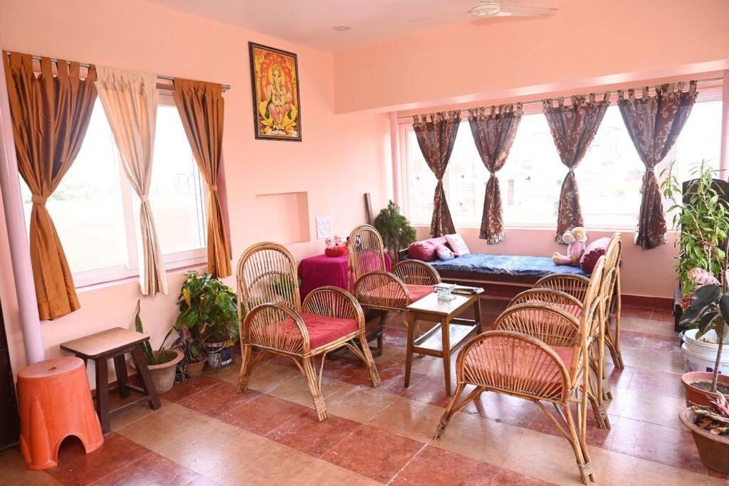 Una sala de estar con sillas, una mesa y un sofá. en Beautiful GardenTerrace 2 Bhk in Posh city center, en Bhubaneshwar