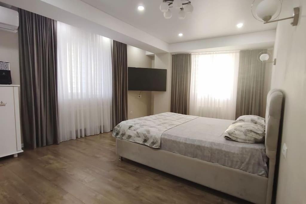 a bedroom with a bed and a large window at Apartament de lux, 2 dormitoare! in Chişinău