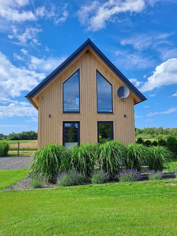a house with glass windows on a green lawn at Norbea in Sasino