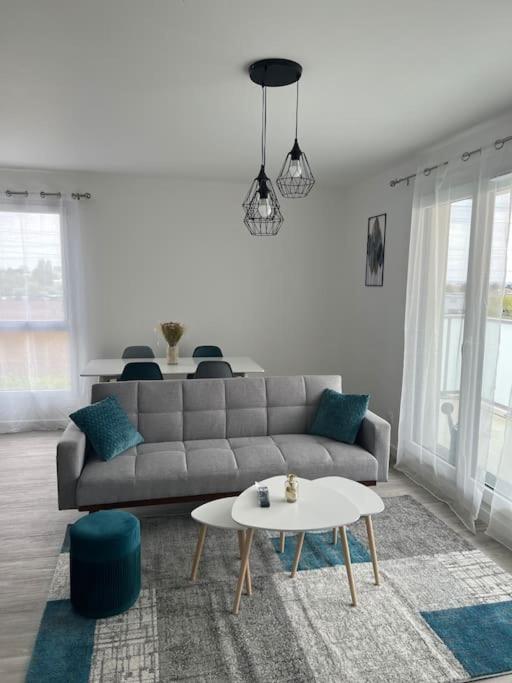 un salon avec un canapé et une table dans l'établissement Appartement F3 cozy avec balcon proche de Paris et aéroport CDG, à Villiers-le-Bel