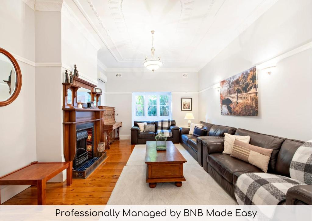 a living room with a couch and a fireplace at Kilbirnie - Stroll to CBD, Heritage, Sleeps 10 in Dubbo
