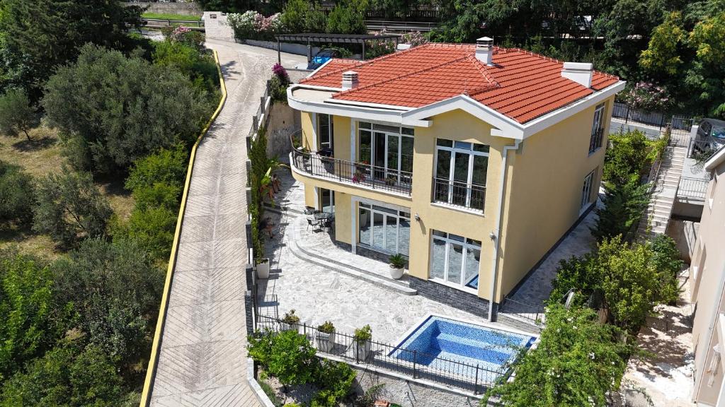 an overhead view of a yellow house with a red roof at Village Gals in Đenovići