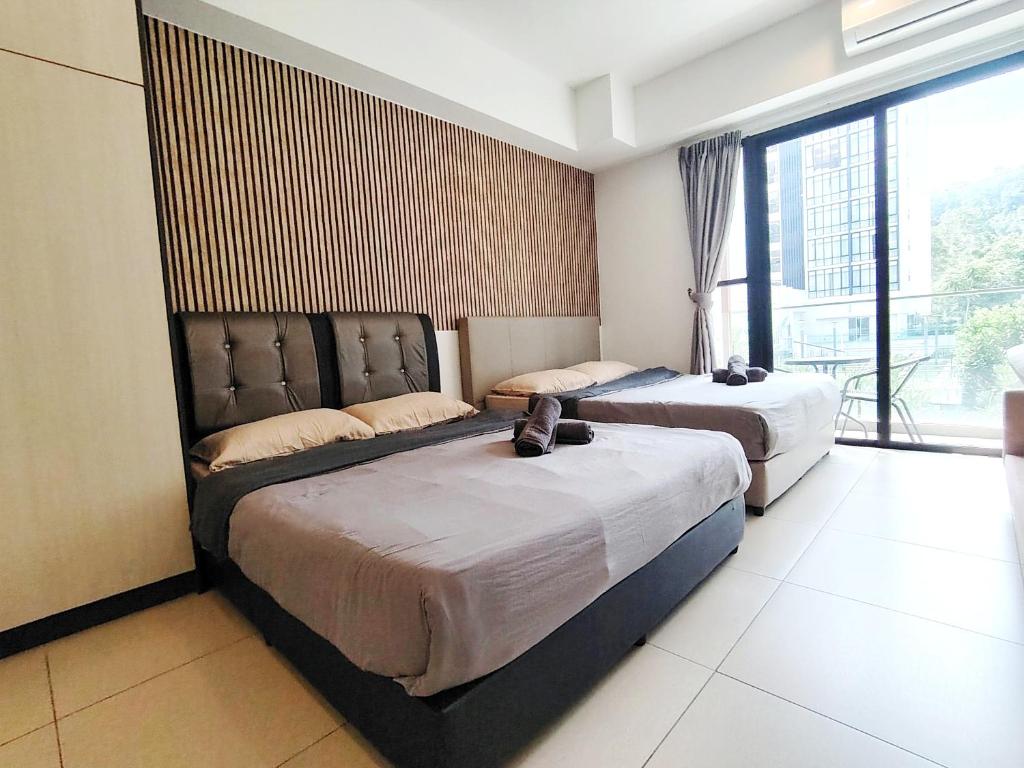 een slaapkamer met twee bedden en een groot raam bij Holiday At Midhills Genting Highlands Free Wi-Fi in Genting Highlands