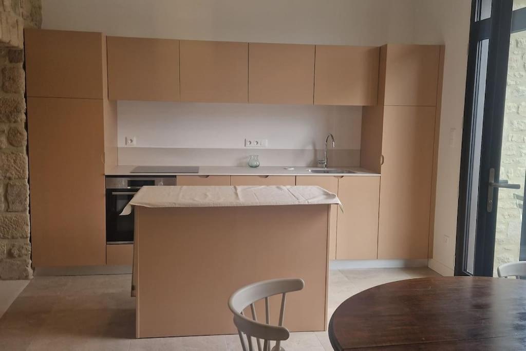 une cuisine avec un comptoir et une table avec des chaises dans l'établissement Le gîte Le Magnolia, à Carnac