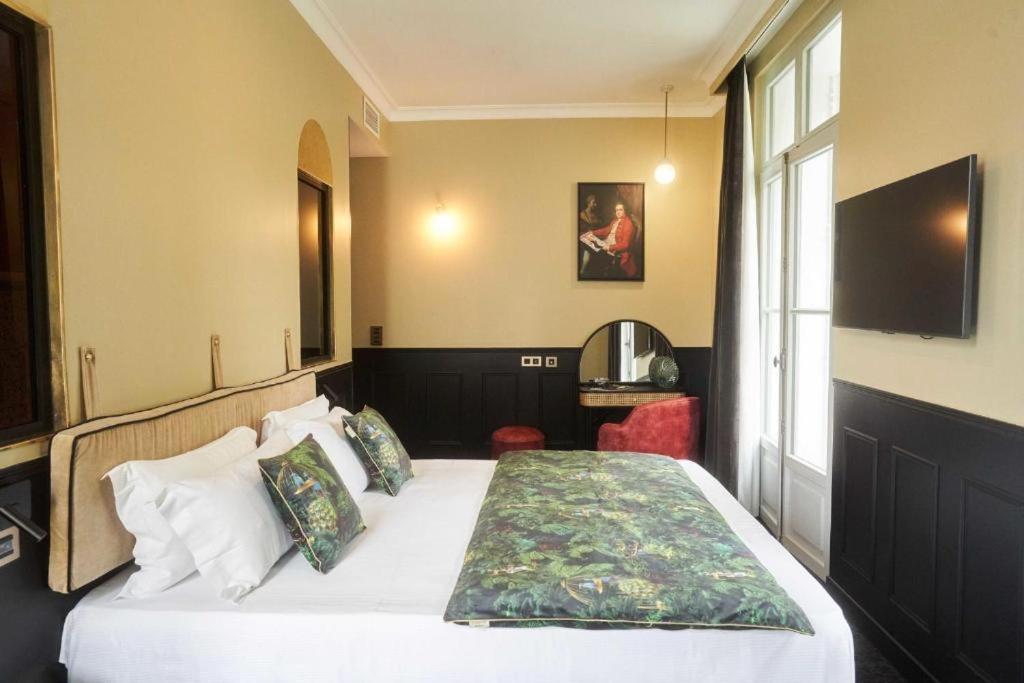une chambre avec un lit et une télévision dans l'établissement Maison Bayard, à Montpellier