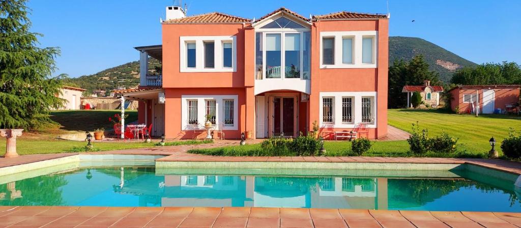 a house with a swimming pool in front of a house at Villa AVRA in Drama