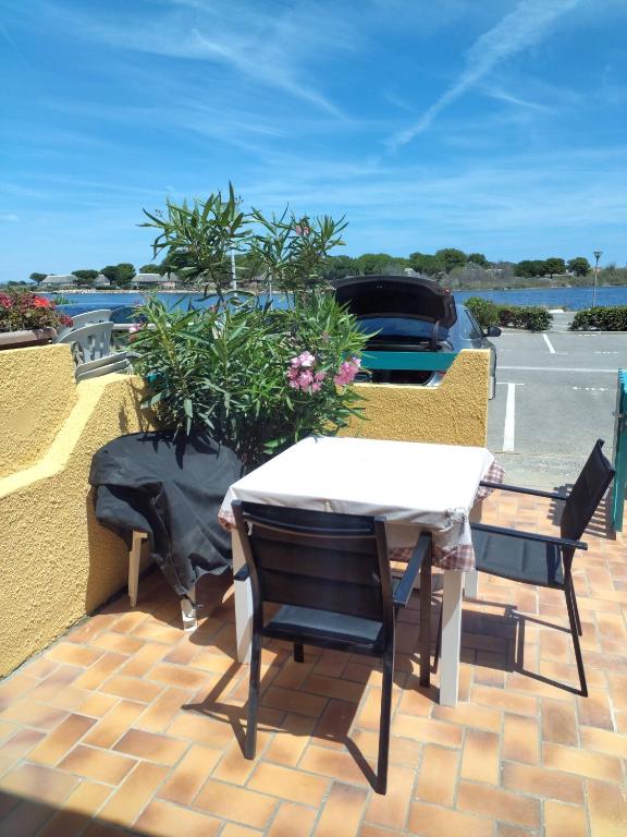 un patio avec une table et des chaises sur un toit dans l'établissement Résidence Marina Soleil Bleu, au Barcarès