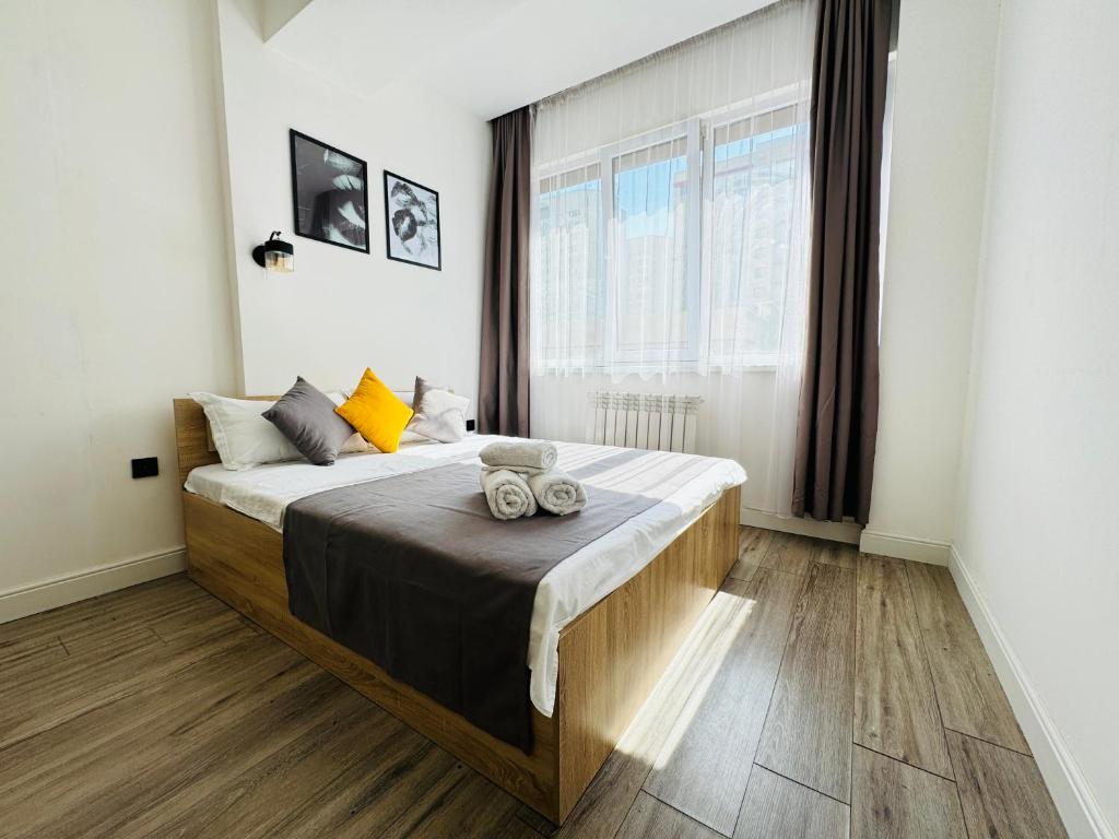 a bedroom with a bed and a large window at 417I1 Gray and Yellow apartment Sholpan city in Almaty