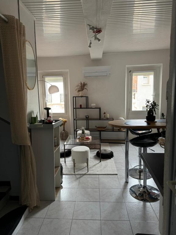 un salon avec une table et une salle à manger dans l'établissement Duplex moderne centre du Boulou, au Boulou