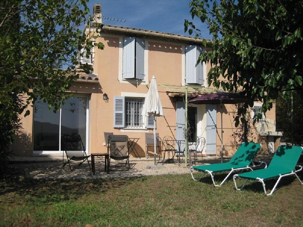 une maison avec des chaises et un parasol dans la cour dans l'établissement Chez marcel les arcs, aux Arcs-sur-Argens