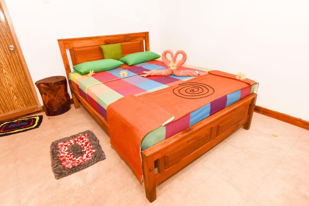 a bedroom with a bed with a colorful comforter at Elephant Trio Sigiriya in Sigiriya