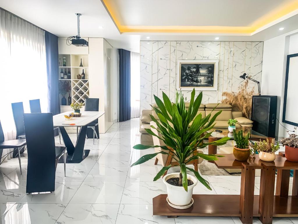 a dining room and living room with a table and plants at Green Line Long Bien - Serviced Apartment - Ngoc Thuy - Hanoi in Hanoi