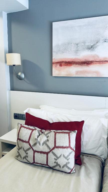 a bed with a pillow and a painting on the wall at Hotel Las Olas in Noja
