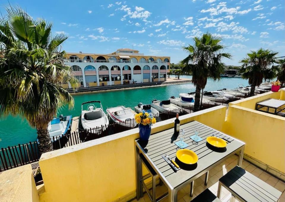un balcon avec une table et une piscine avec des bateaux dans l'établissement T2 Mer et Soleil avec Terrasse, à Sète