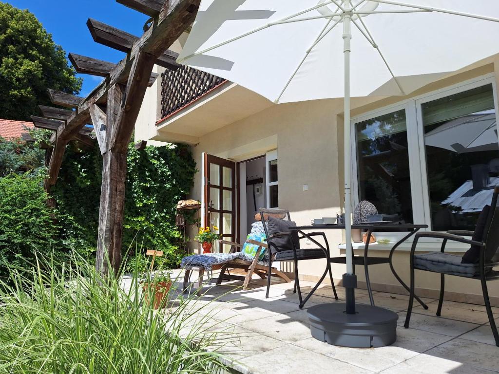 a patio with a table and chairs and an umbrella at Studio Dom Nałęczowski in Nałęczów