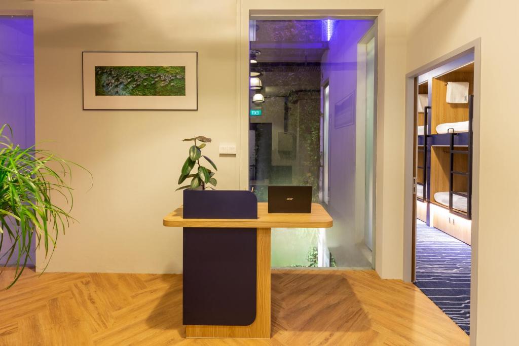 a desk in a hallway with a laptop on it at Bluewaters Female-Only Hostel in Singapore