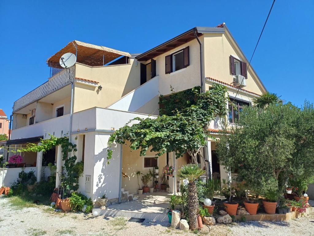 a large house with plants in front of it at Apartmani Saška 2 in Privlaka